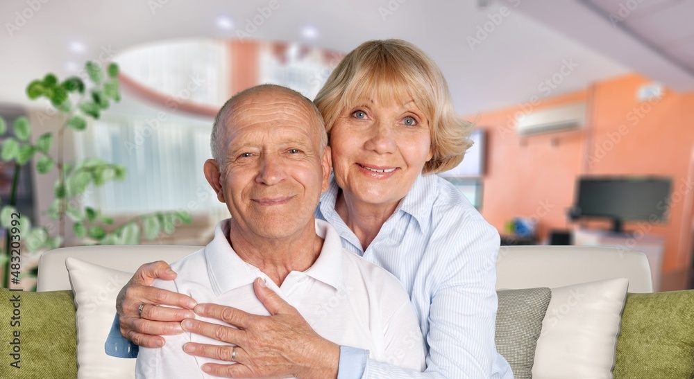 old retired age couple watching TV at home, on sofa couch at living room home