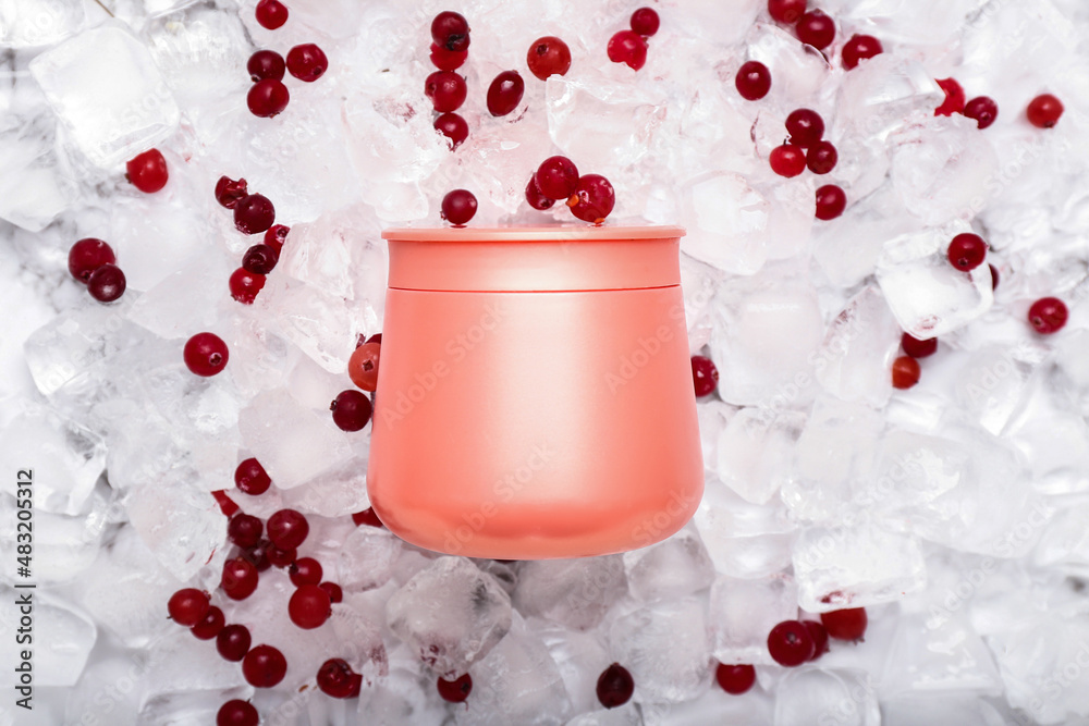 Cosmetic jar on ice cubes background