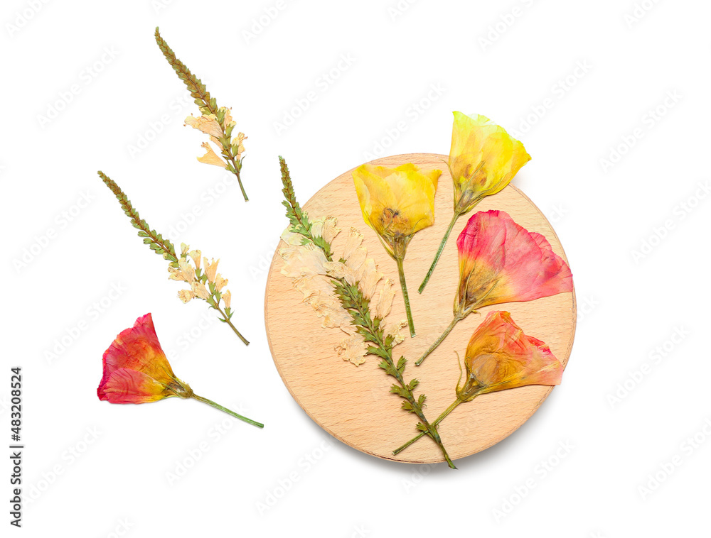 Wooden board with dried pressed flowers on white background