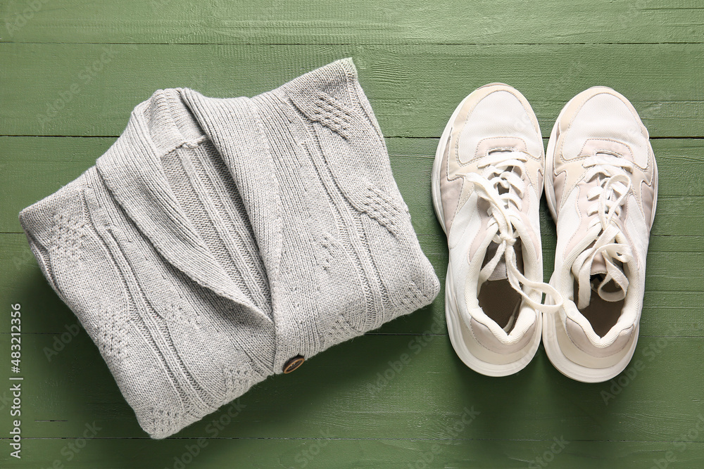 Male sweater and shoes on color wooden background