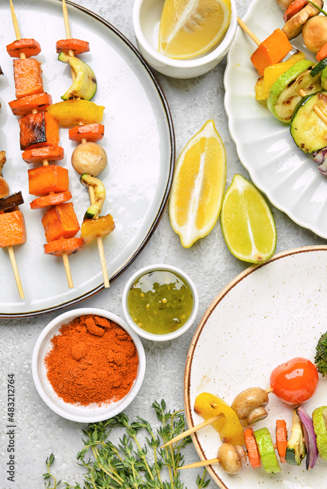 Composition with tasty vegetable skewers and sauce on light background