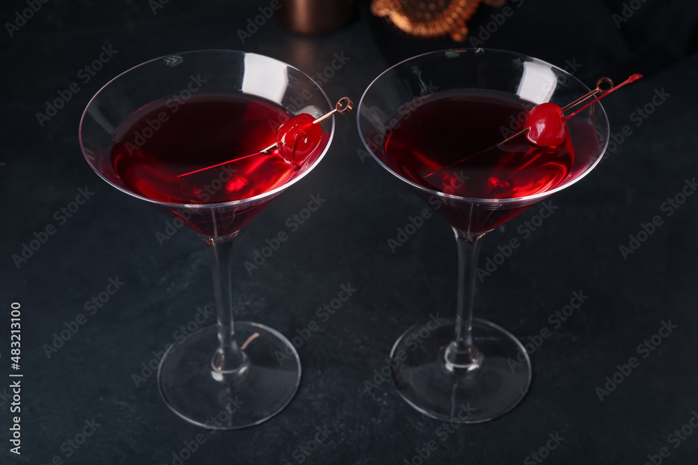 Glasses of tasty Manhattan cocktail on black background