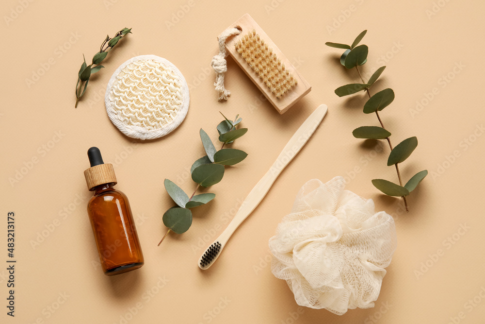 Composition with bath supplies, bottle of essential oil and eucalyptus branches on color background