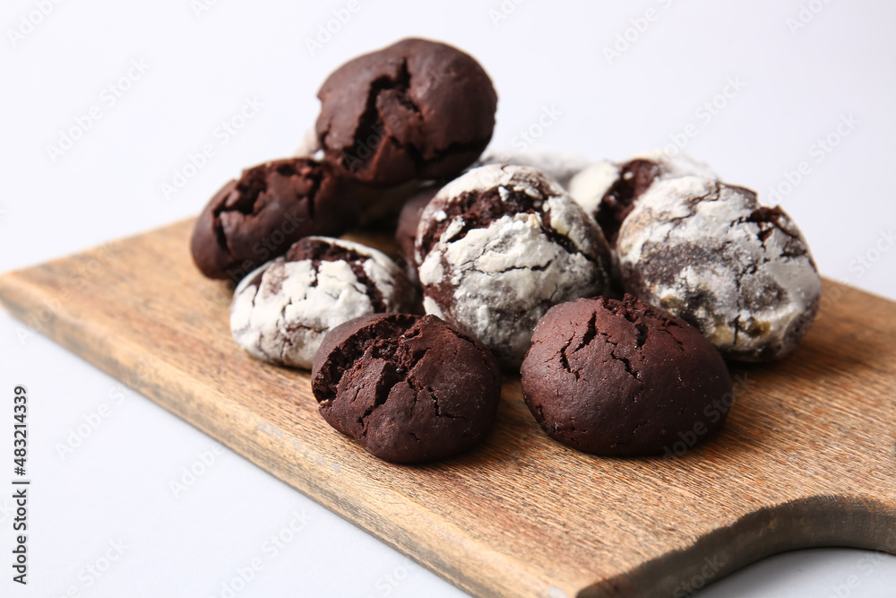 Board with tasty brownie cookies on light background