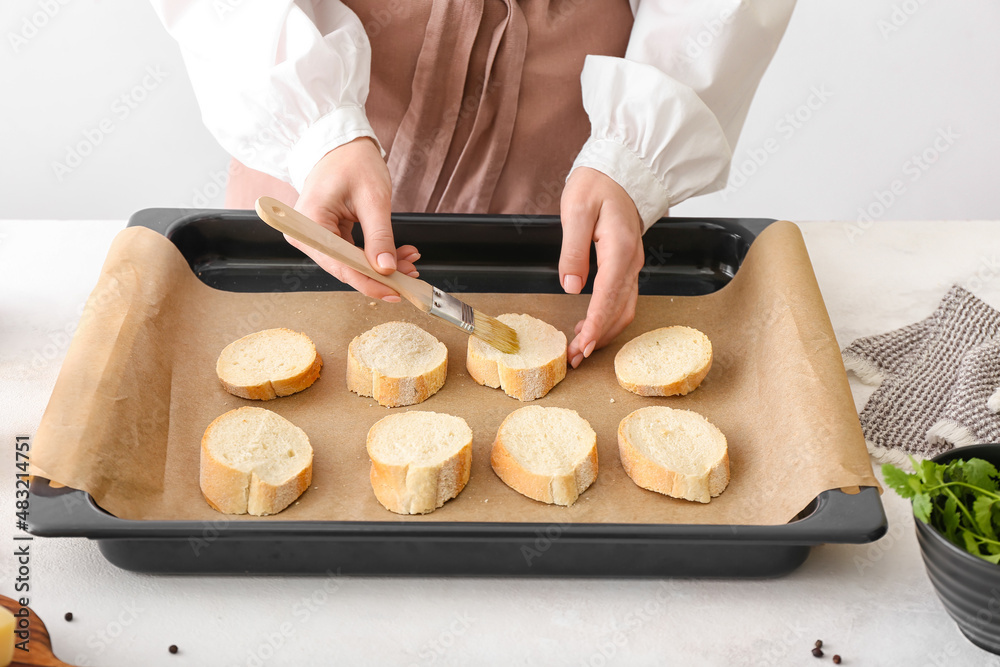 Woman preparing croutons at kitchen table, closeup