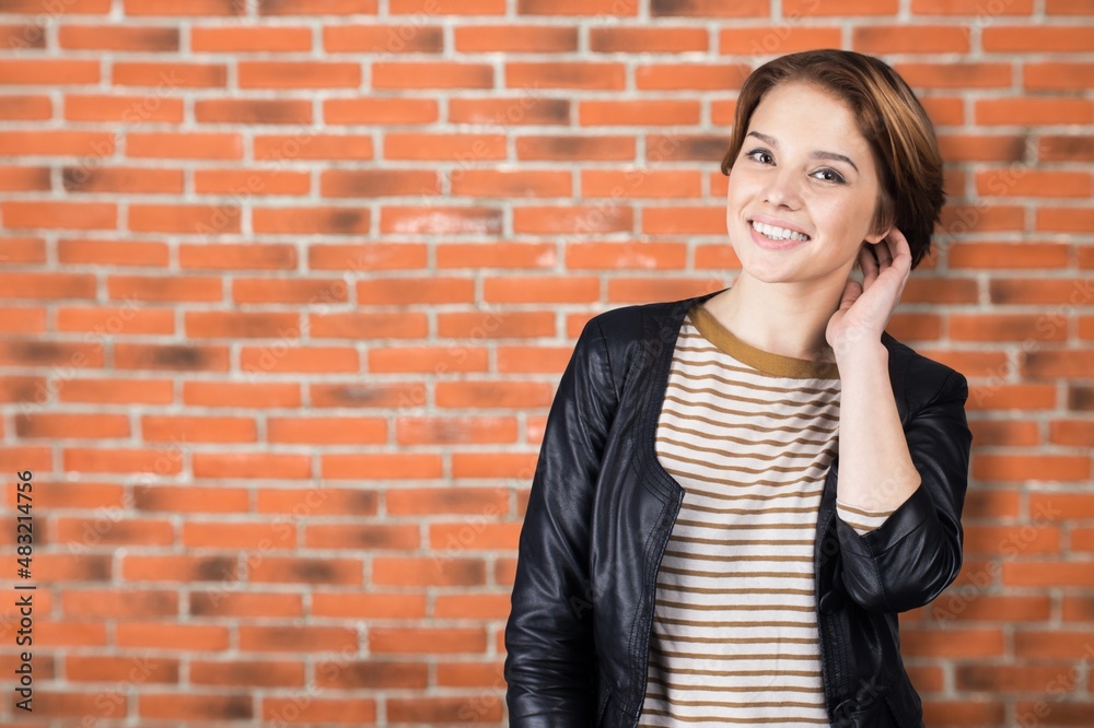 Attractive beautiful positive woman, over the brick wall. Portrait