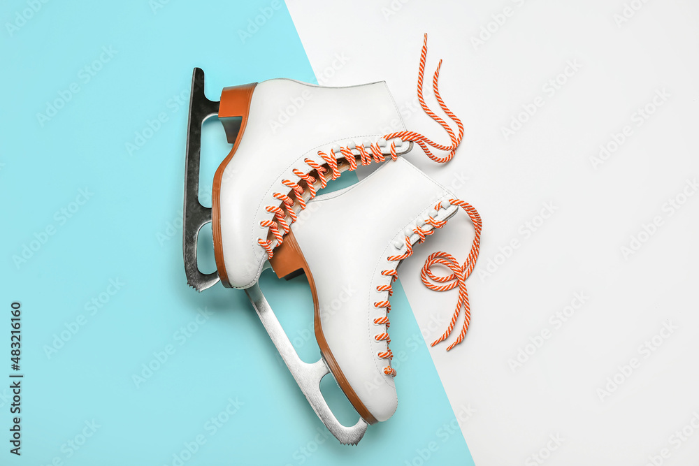 Stylish ice skates on color background