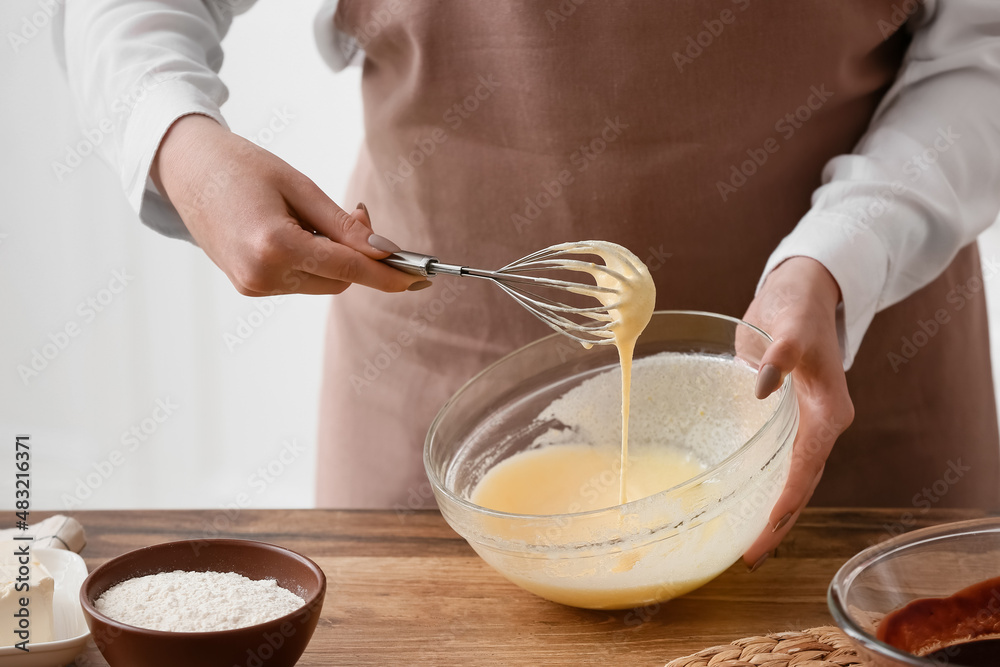 Woman preparing chocolate brownie at kitchen table, closeup