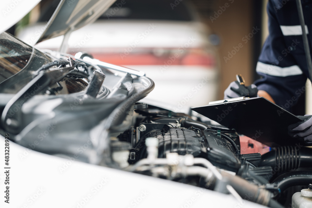 Mechanic works on the engine of the car in the garage. Repair service. Concept of car inspection ser