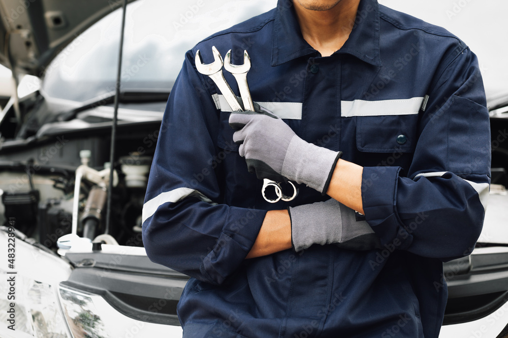 Hand of car mechanic with wrench. Auto repair garage. mechanic works on the engine of the car in the