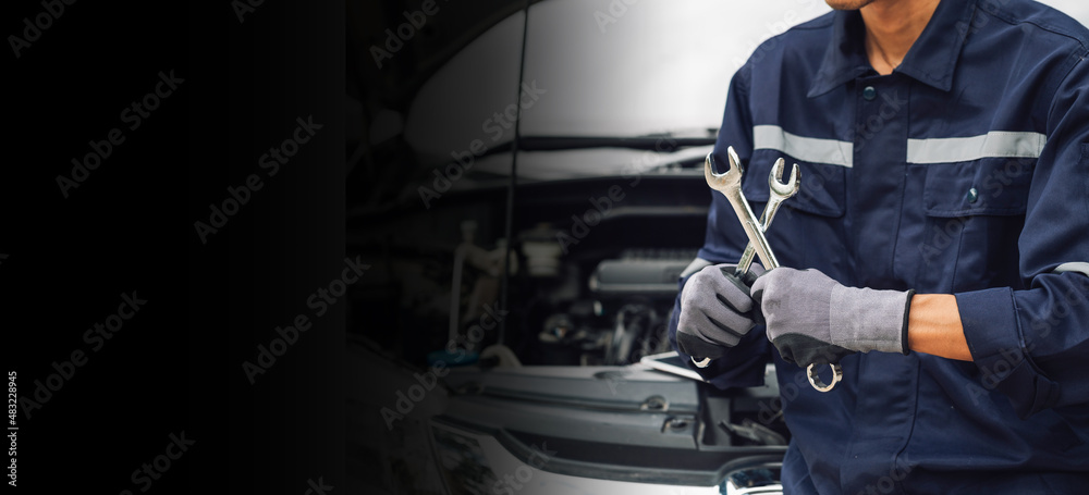 Hand of car mechanic with wrench. Auto repair garage. mechanic works on the engine of the car in the