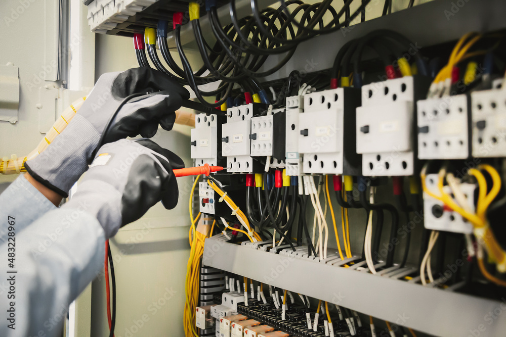 Electrical engineers test electrical installations and wiring on protective relays, measuring them w