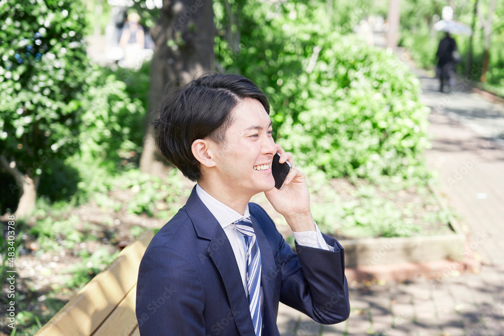 ビジネスマン　電話する　屋外