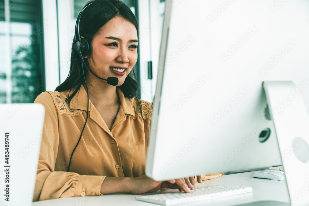 Businesswoman wearing headset working actively in office . Call center, telemarketing, customer supp