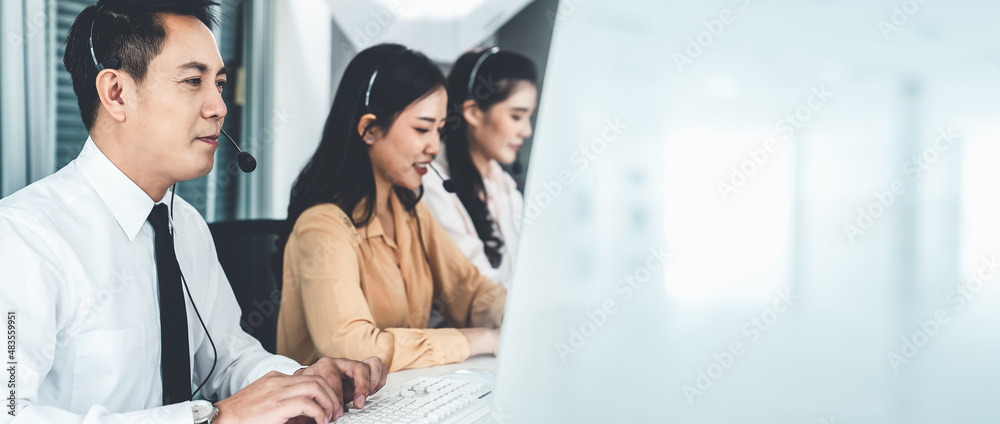 Business team wearing headset working actively in office . Call center, telemarketing, customer supp