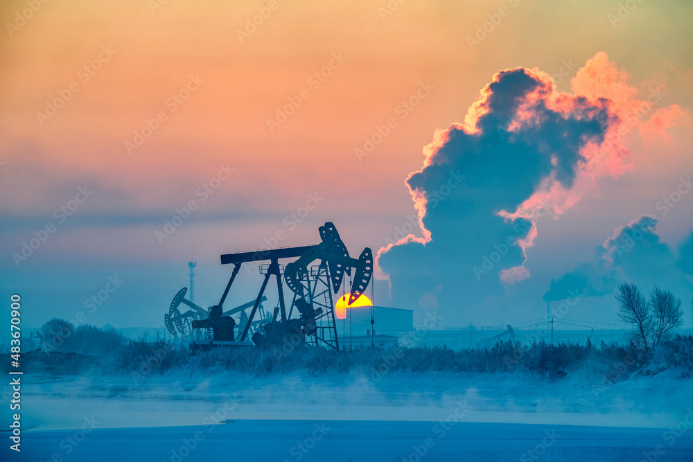 The oil pumping units in lakeside in winter in Daqing oil fields, China.