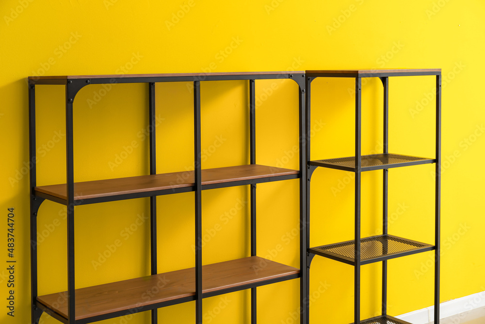 Modern standing shelving unit near yellow wall