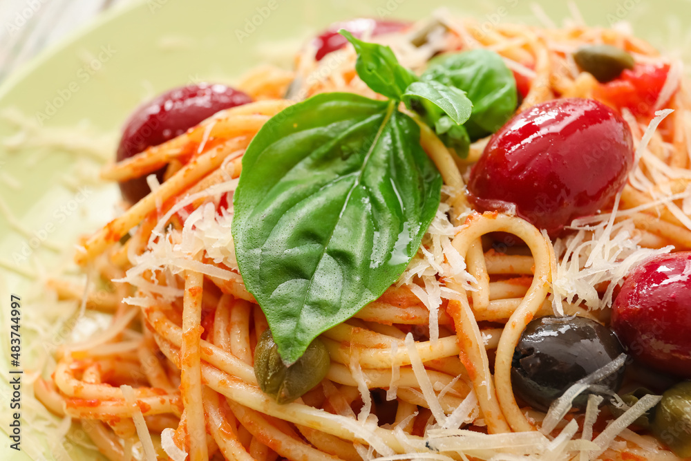 Plate of tasty Pasta Puttanesca on table, closeup