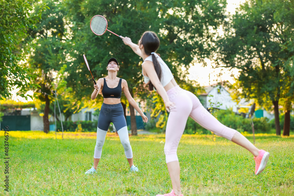 Young women playing badminton outdoors