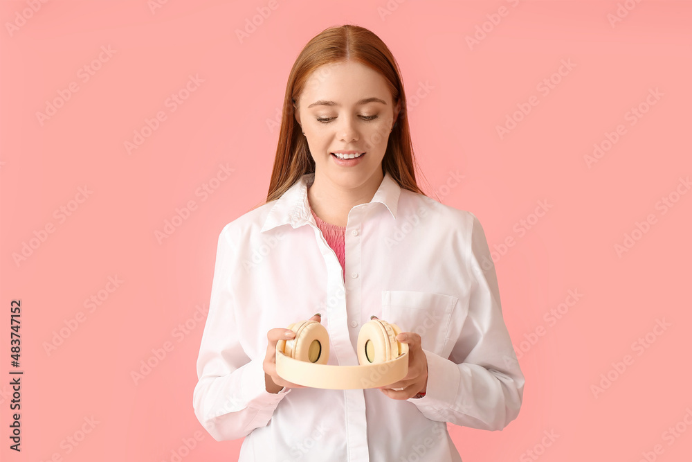 Cool young woman with headphones on color background