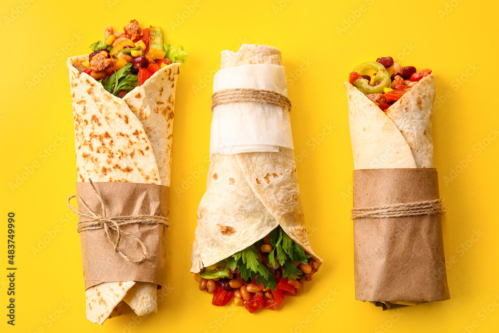 Delicious burritos on yellow background