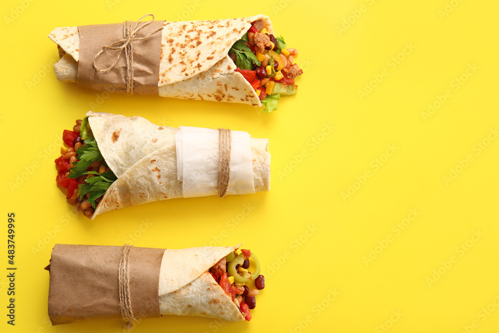 Delicious burritos on yellow background