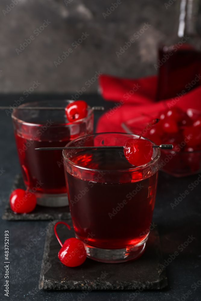 Glasses of tasty Manhattan cocktail on black background