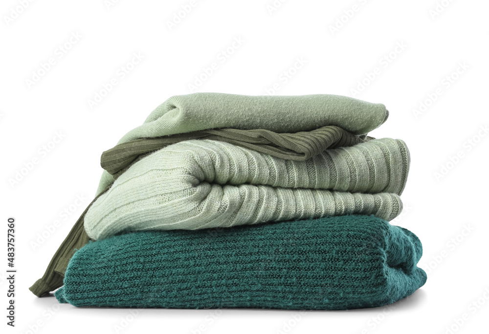 Stack of knitted sweaters on white background