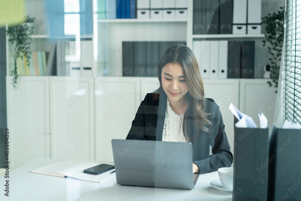 Asian beautiful business woman smile feel happy while work in office.