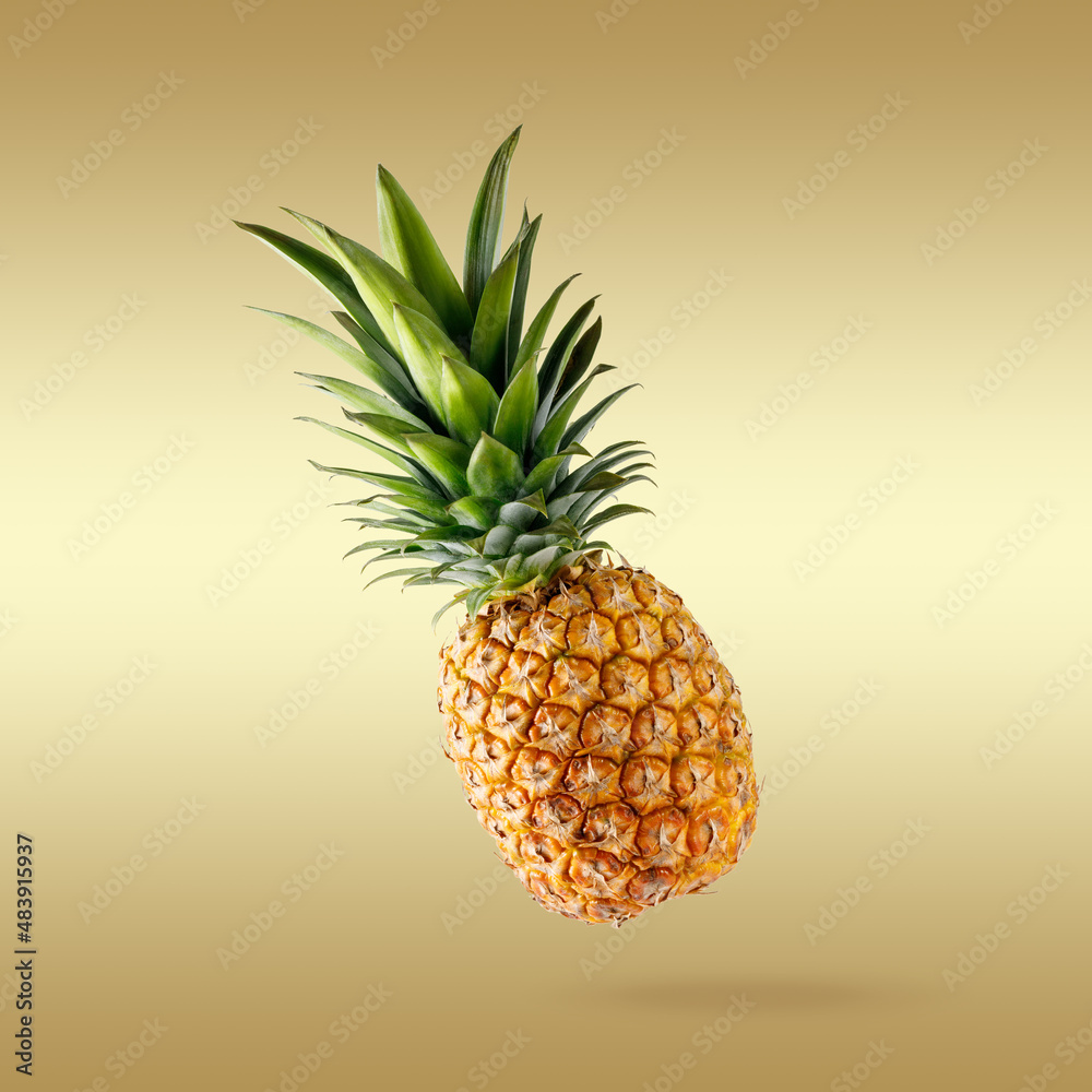 Fresh juicy tropical fruit pineapple flying on gradient golden background.