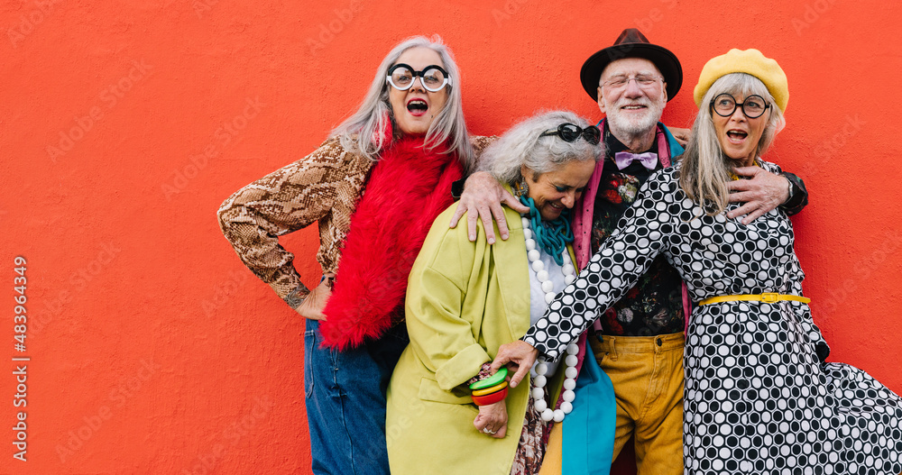 Vibrant senior citizens having fun against a red background