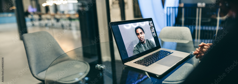 Unrecognizable businesswoman attending a virtual meeting in an office