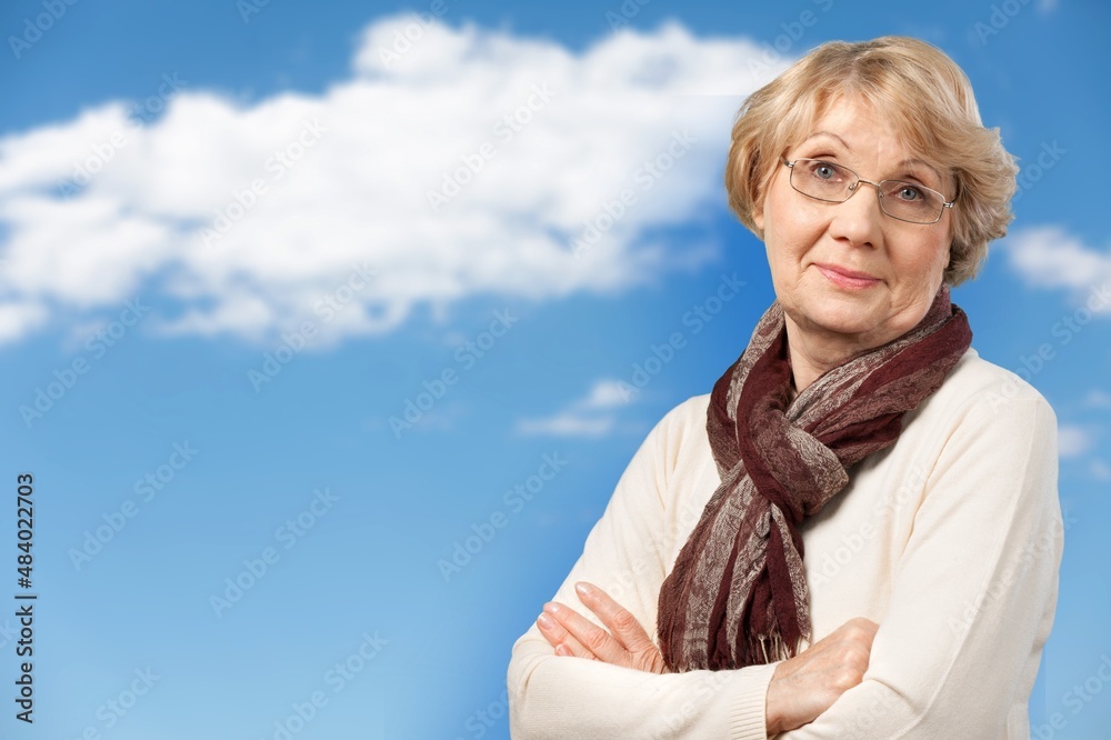 Cheerful middle aged woman standing against background with arms crossed. Confidence concept.