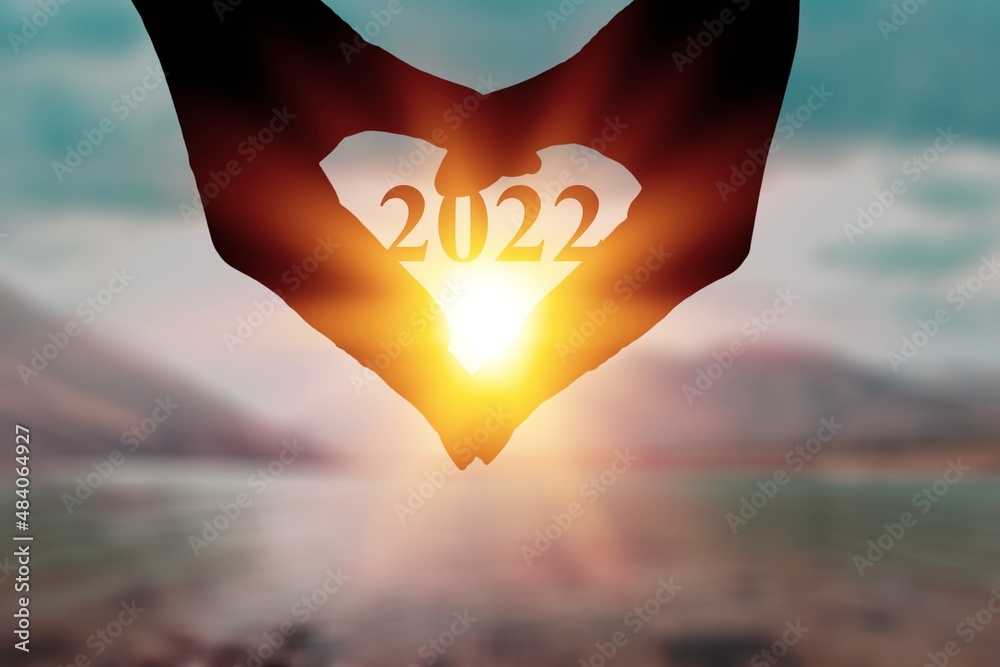 New year inspirational motivational, person holding a heart shaped hands with 2022 number inside.