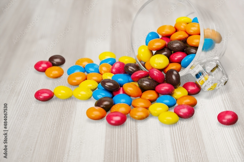 Group of colored multivitamin gummies with the bottle on the desk