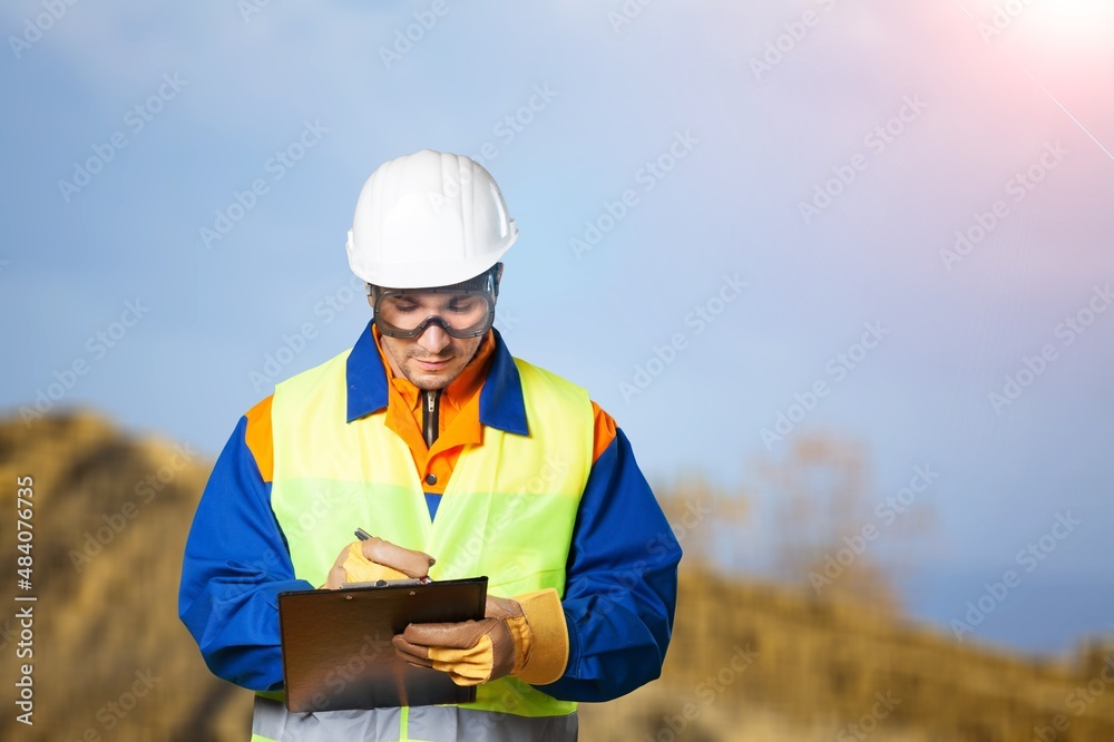 A young coal mine foreman wearing a hard hat work on site