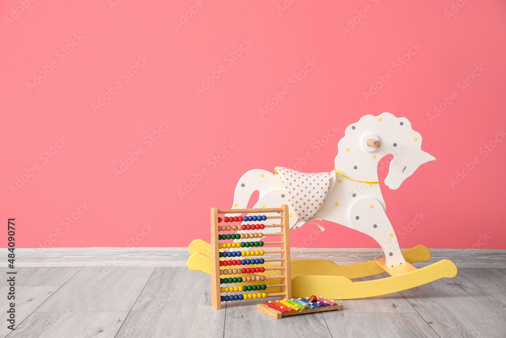 Rocking horse, abacus and xylophone near color wall