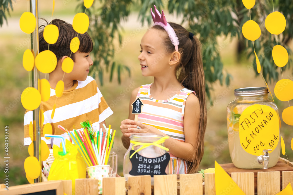 Cute children selling lemonade in park