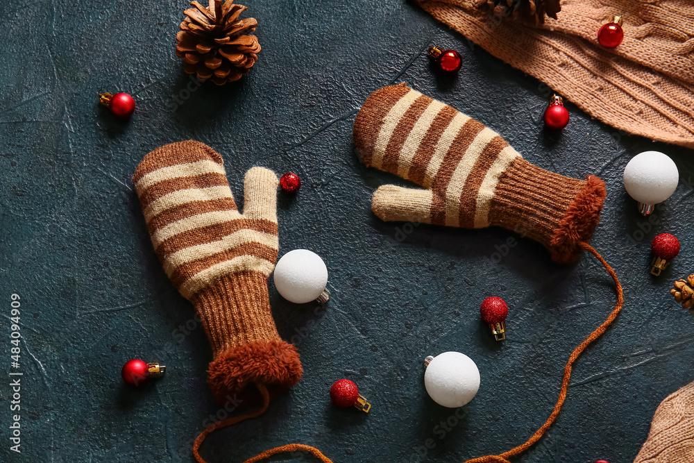 Warm gloves and Christmas decor on black background