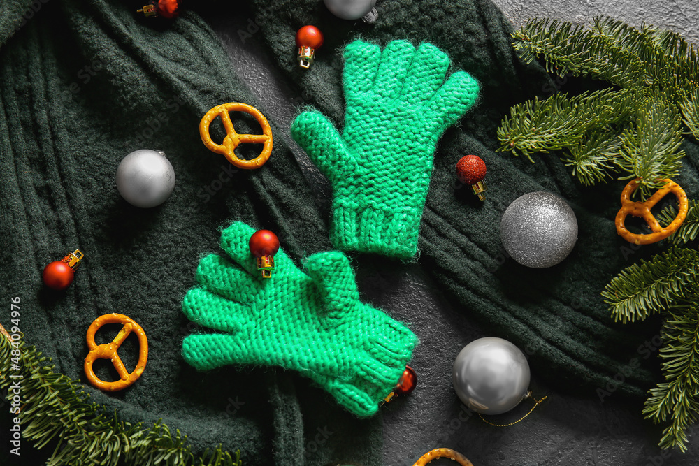 Warm gloves, scarf and Christmas decor on black background