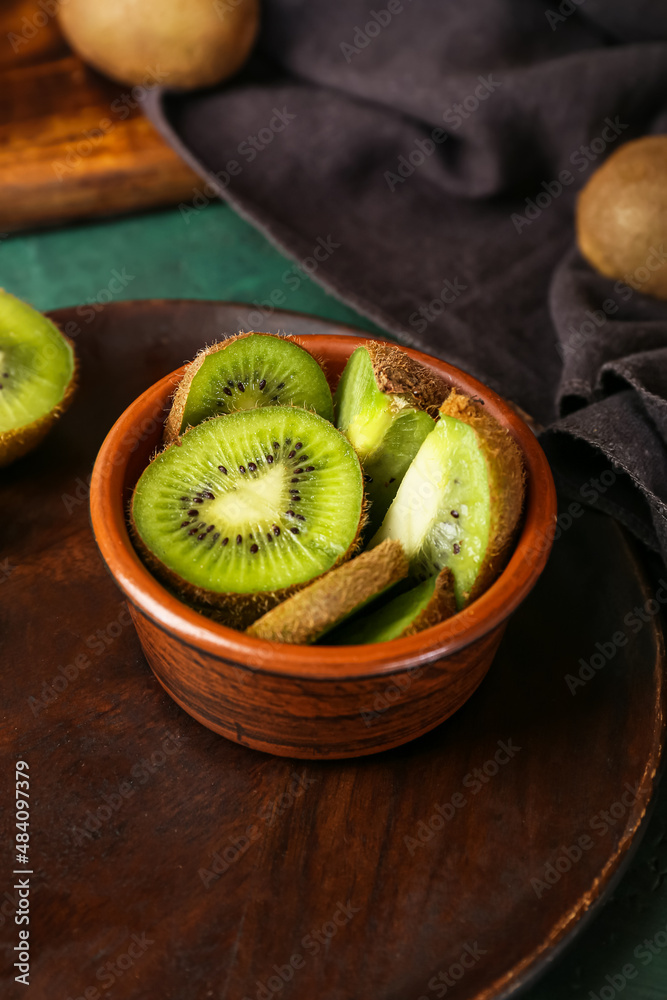 Bowl with fresh cut kiwi on table, closeup