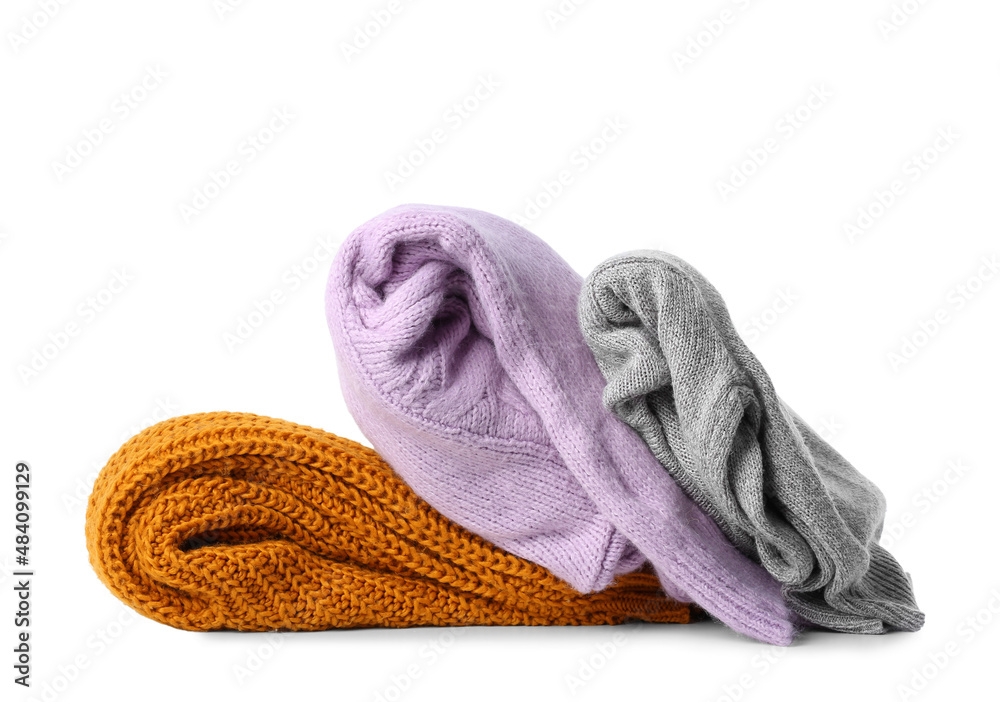 Folded warm sweaters on white background