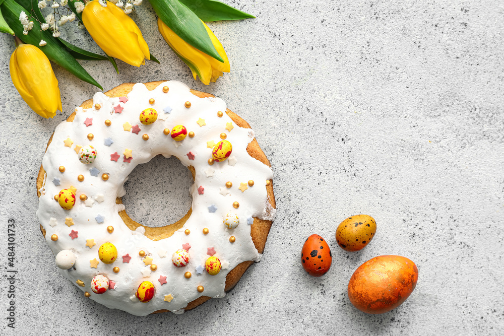 Tasty Easter cake, tulip flowers and eggs on light background