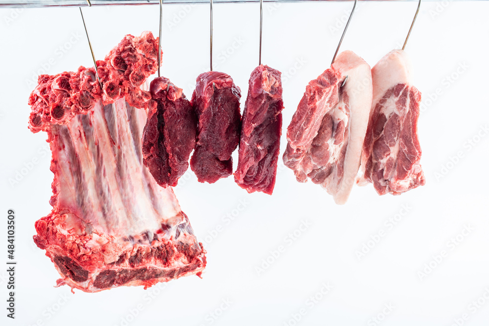 Fresh beef and pork hanging from a meat stall