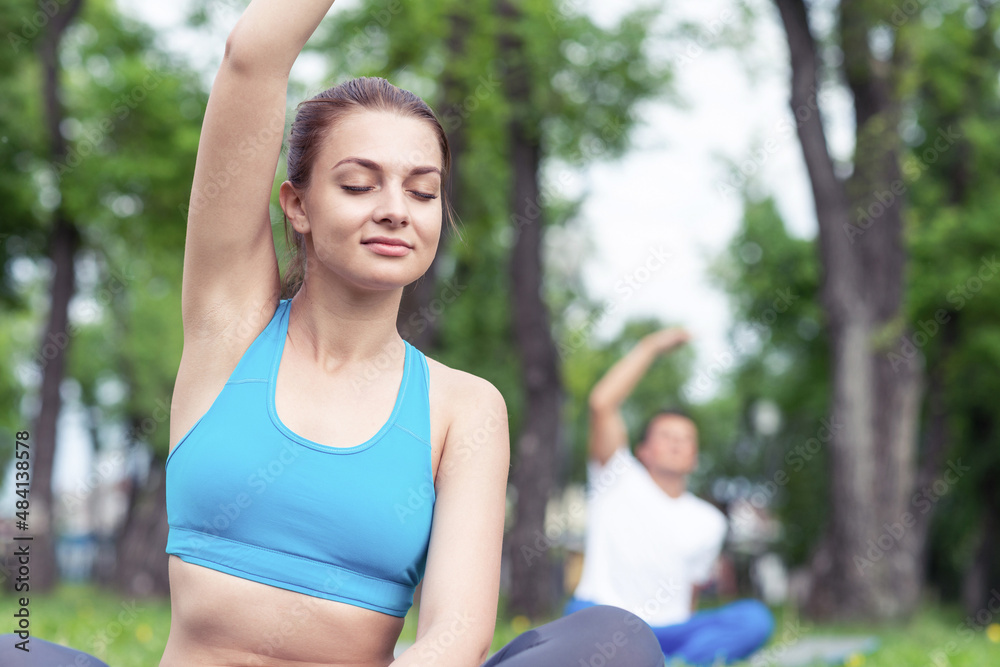 Young couple doing yoga in park together