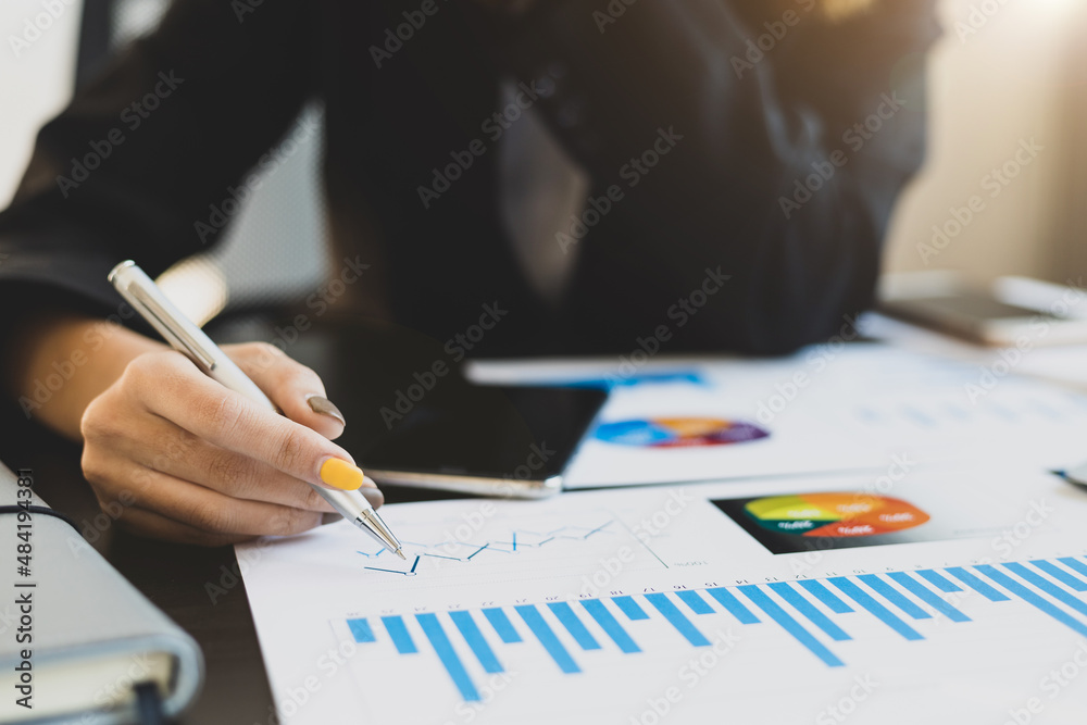 Close-up business woman analyzing business report and planning.