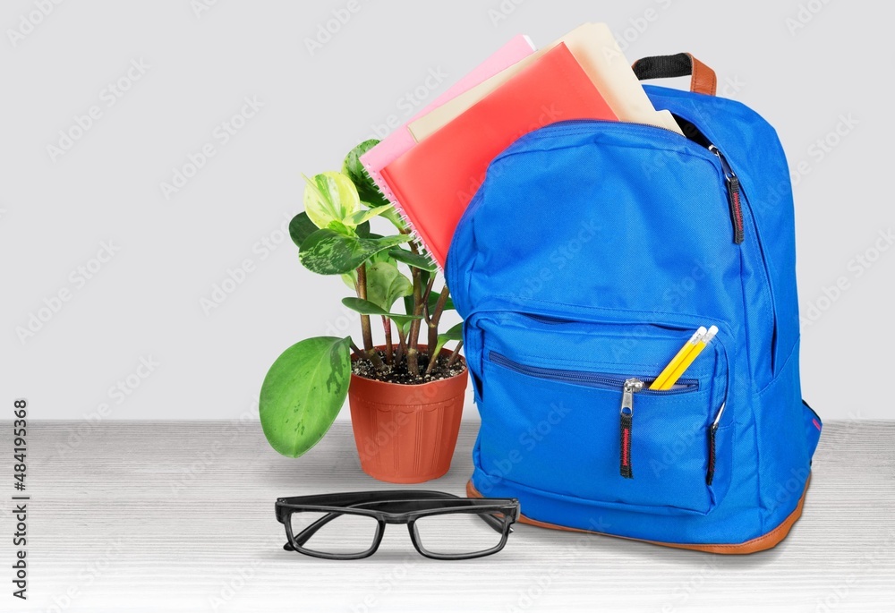 Bright backpack on table home. School supplies. Back to school concept. Educational design objects.