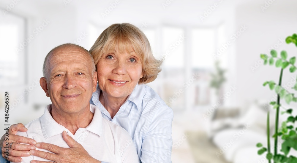 old retired age couple watching TV at home, on sofa couch at living room home