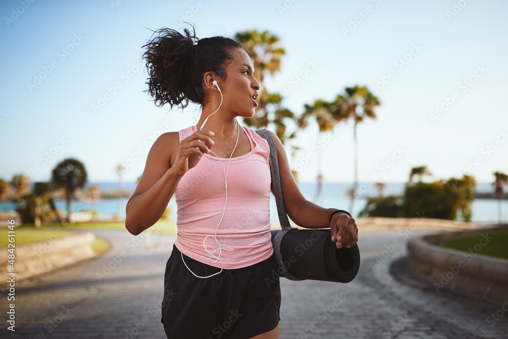 Young woman in sportswear smiling while walking to yoga class