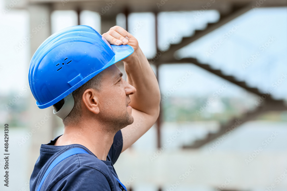 Male worker with safety hardhat at construction site